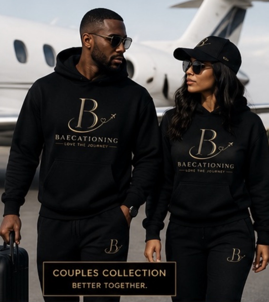 A couple wearing matching black Baecationing hoodies in front of a private jet